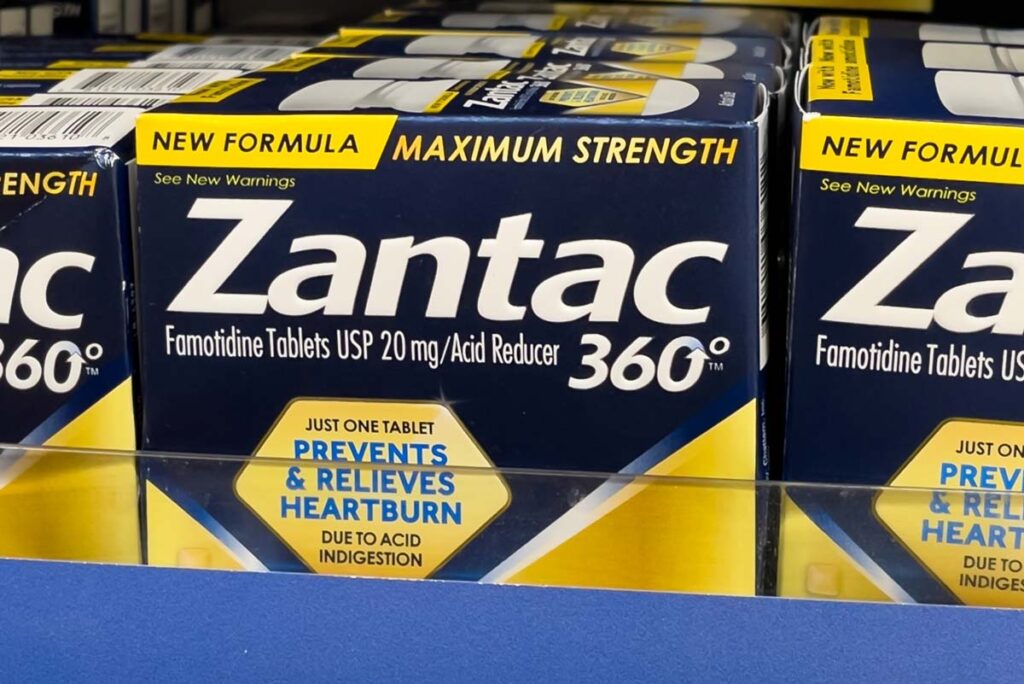 Close up of Zantac products for sale on a supermarket shelf, representing the Zantac lawsuits.