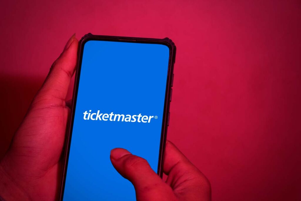 Close up of hands holding a smartphone with Ticketmaster logo displayed, representing the Ticketmaster class action.