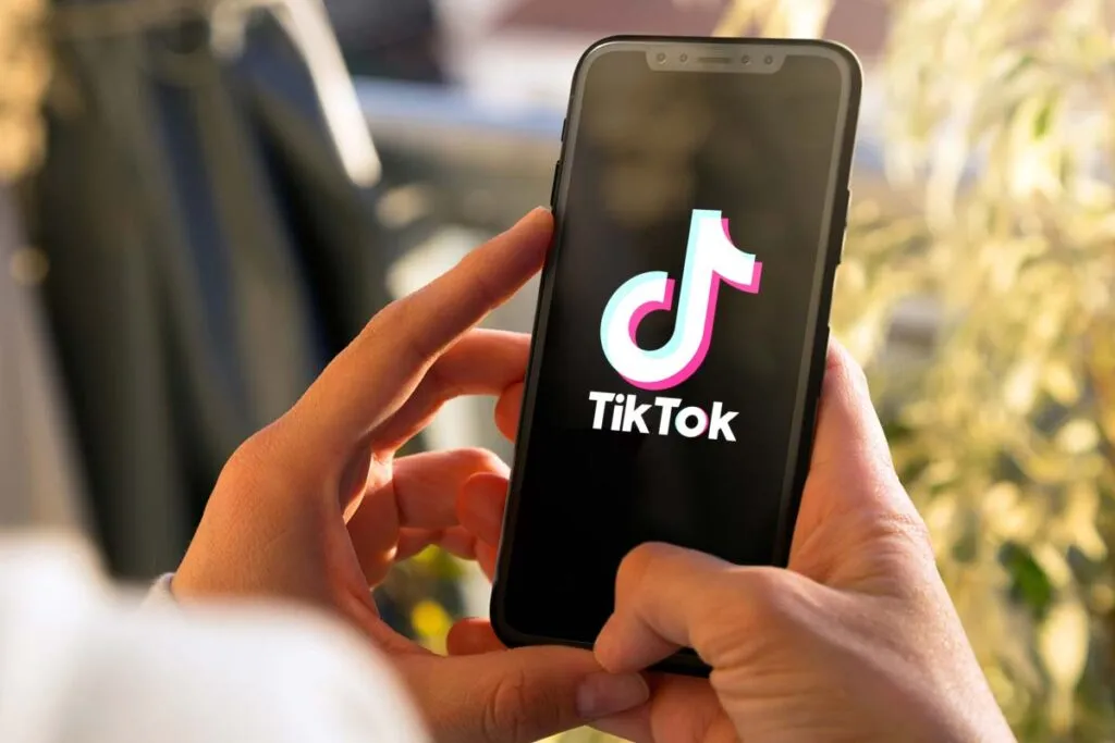 Close up of hands holding a smartphone with the TikTok logo displayed, representing the TikTok lawsuit.