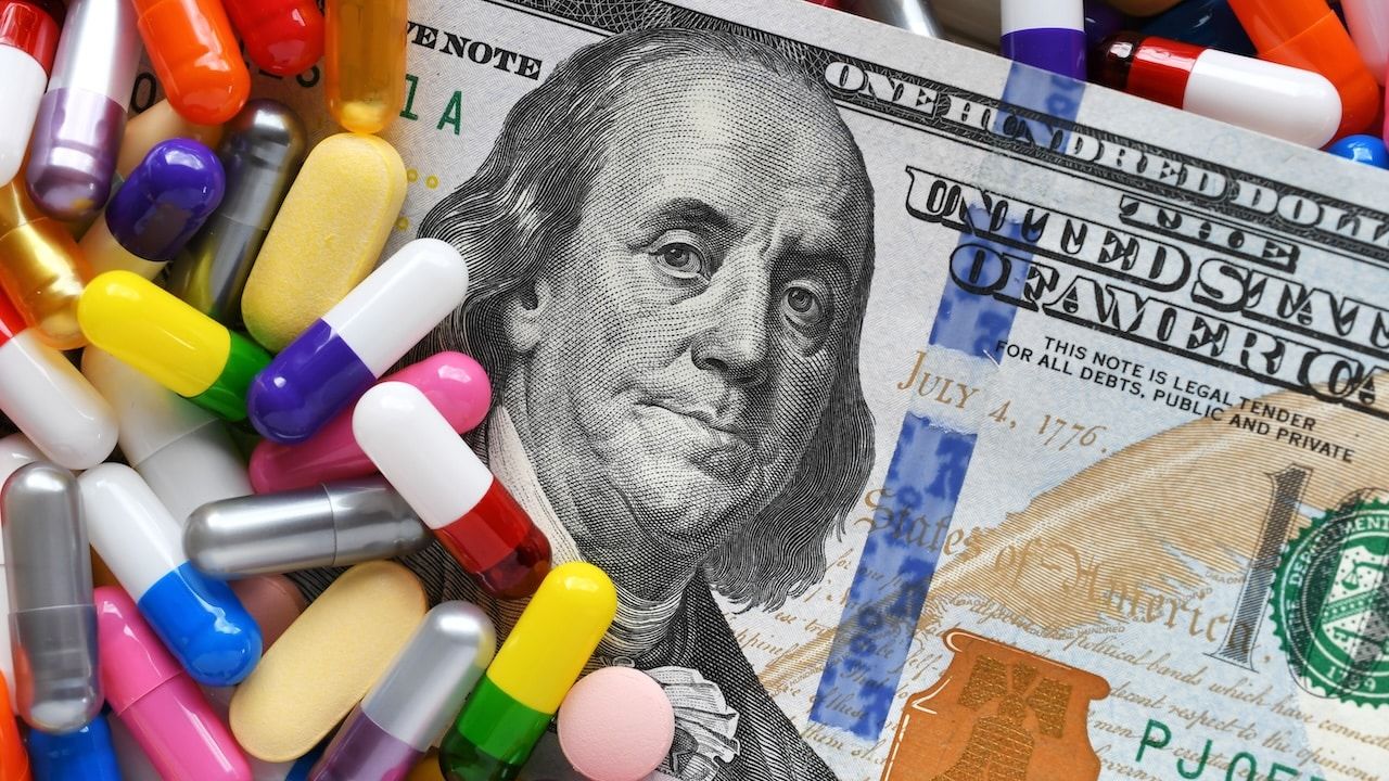 Pills on money dollars - Medicine prescription drugs cost concept