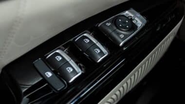 Side door buttons: window, mirror adjustment buttons, door lock. Car inside.