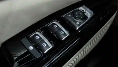 Side door buttons: window, mirror adjustment buttons, door lock. Car inside.