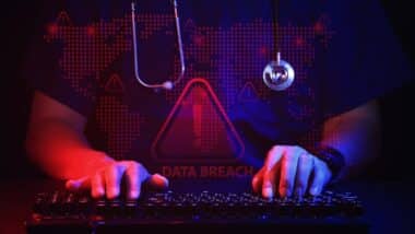 Anxious doctor typing on computer keyboard representing healthcare IT security data breach