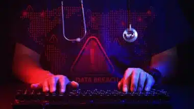 Anxious doctor typing on computer keyboard representing healthcare IT security data breach