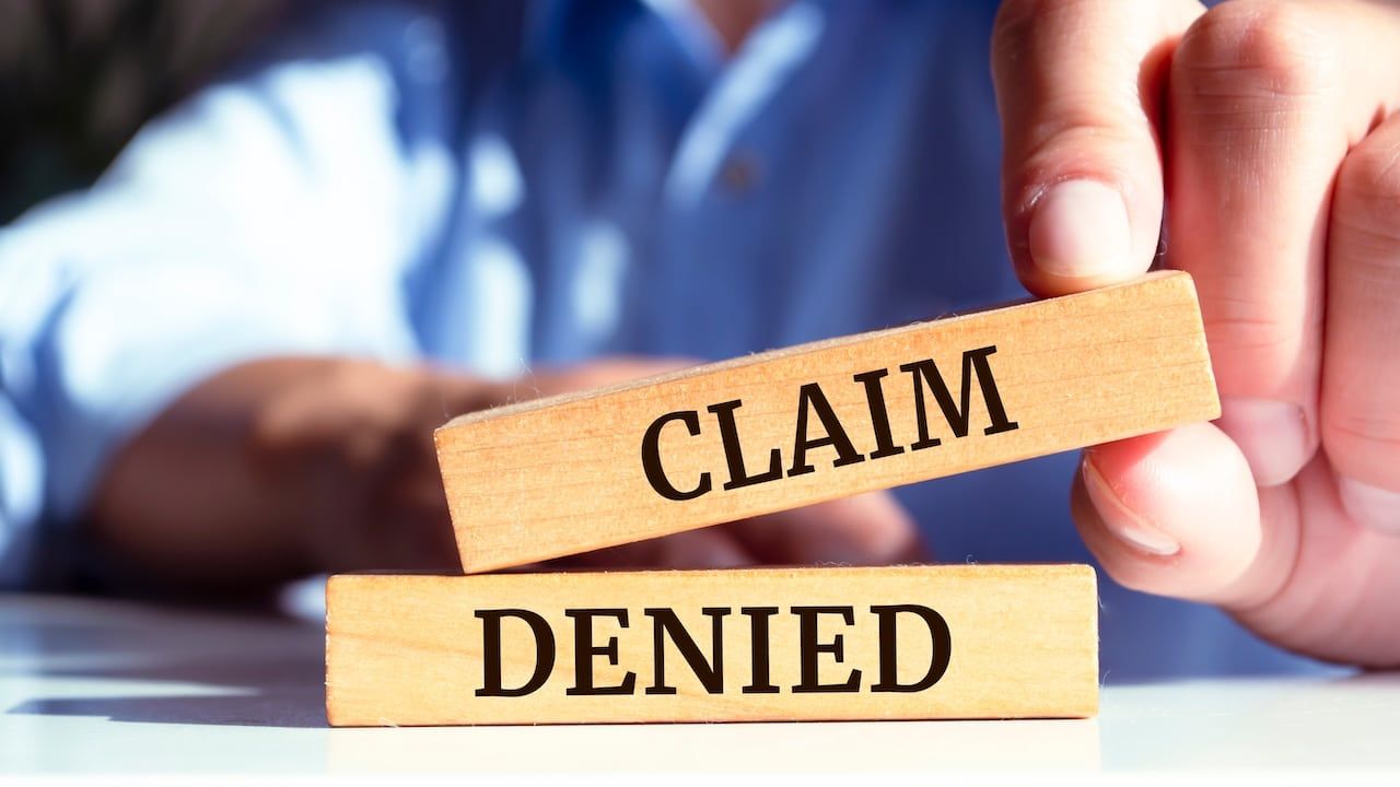 Wooden blocks with words 'Claim denied'.