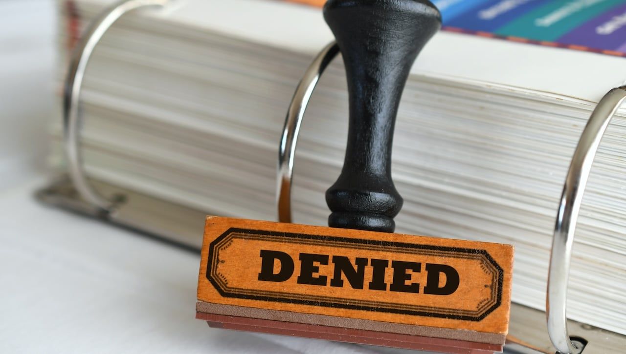 Rubber stamp with word Denied on it.