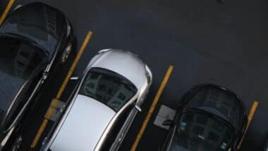 Row of car parking on asphalt lane in modern condominium aerial view
