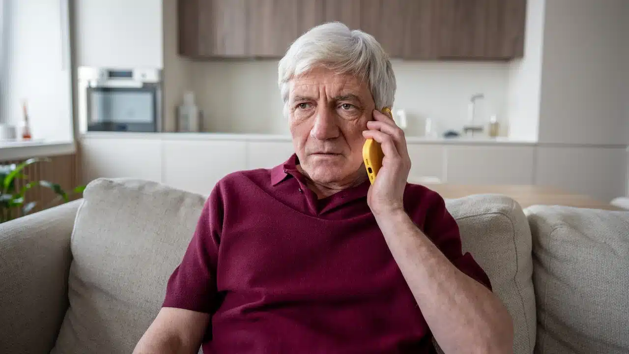 Shock stressed elderly man reacts hanging on phone at home.