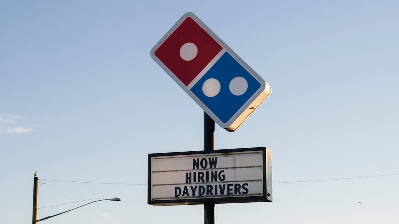 Domino's sign with hiring ads is seen outside one of its locations