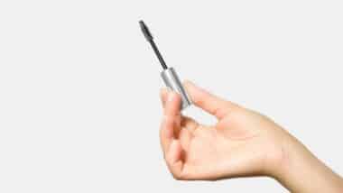 hand holding a brush with eyelash and eyebrow care serum