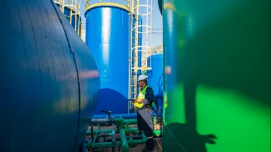 Male worker works permit industry visual inspection the row of big tanks for petrol station.