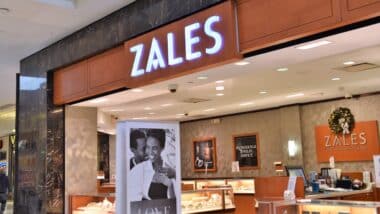 Front view of commercial store front, Zales chain of jewelry store. Shows logo, signs, interior.
