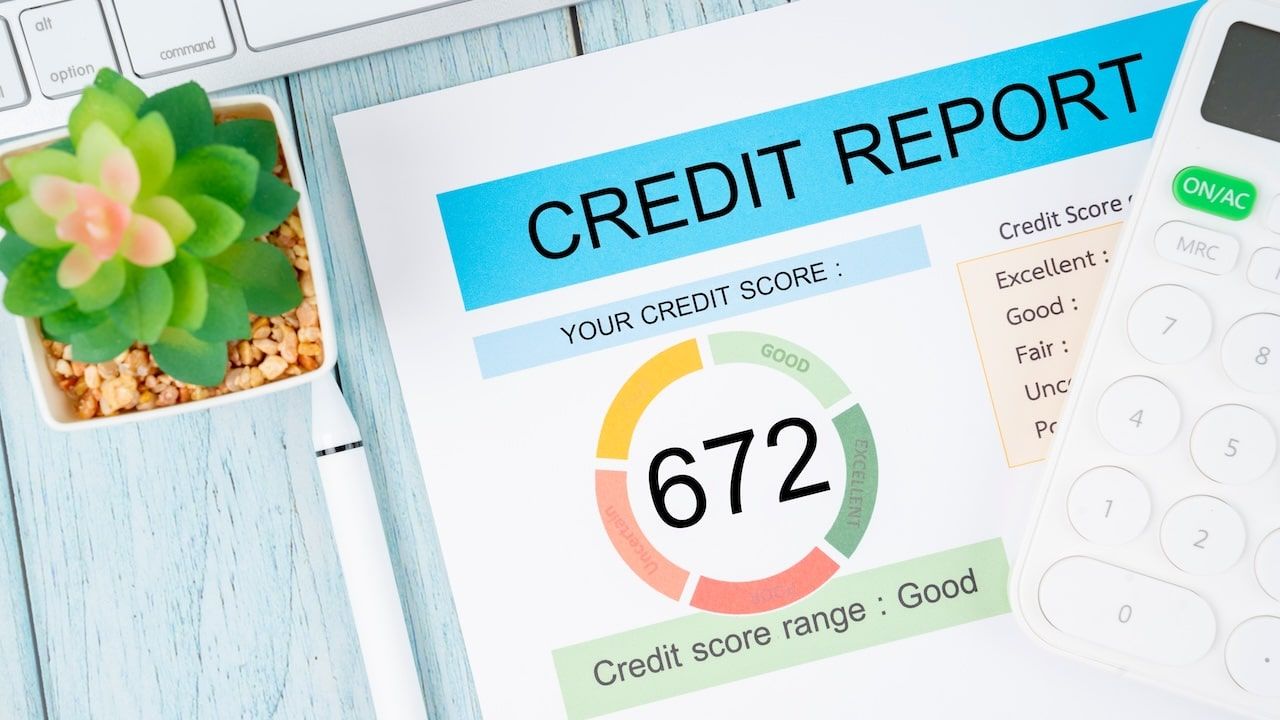 Credit score report document and pen with calculator on the desk.