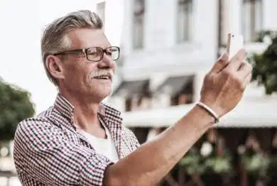 Smiling mature man in casual wear making selfie.
