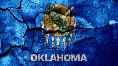 Oklahoma rusted cracked flag, rusty background. United States of America earthquake