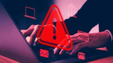 Cyber security alert concept showing hacker hands using laptop with red warning sign, system hack notification, data breach risk, digital attack, network protection, online privacy threat