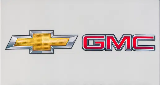 Close up of Chevy GMC pre owned car lot, representing the GM fuel pump settlement.