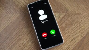 Incoming spam call on mobile phone on table