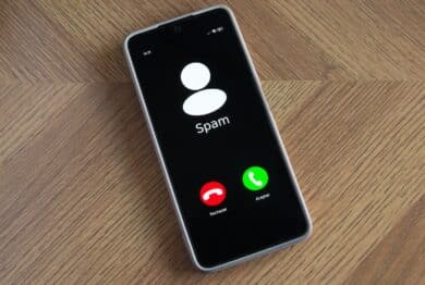 Incoming spam call on mobile phone on table