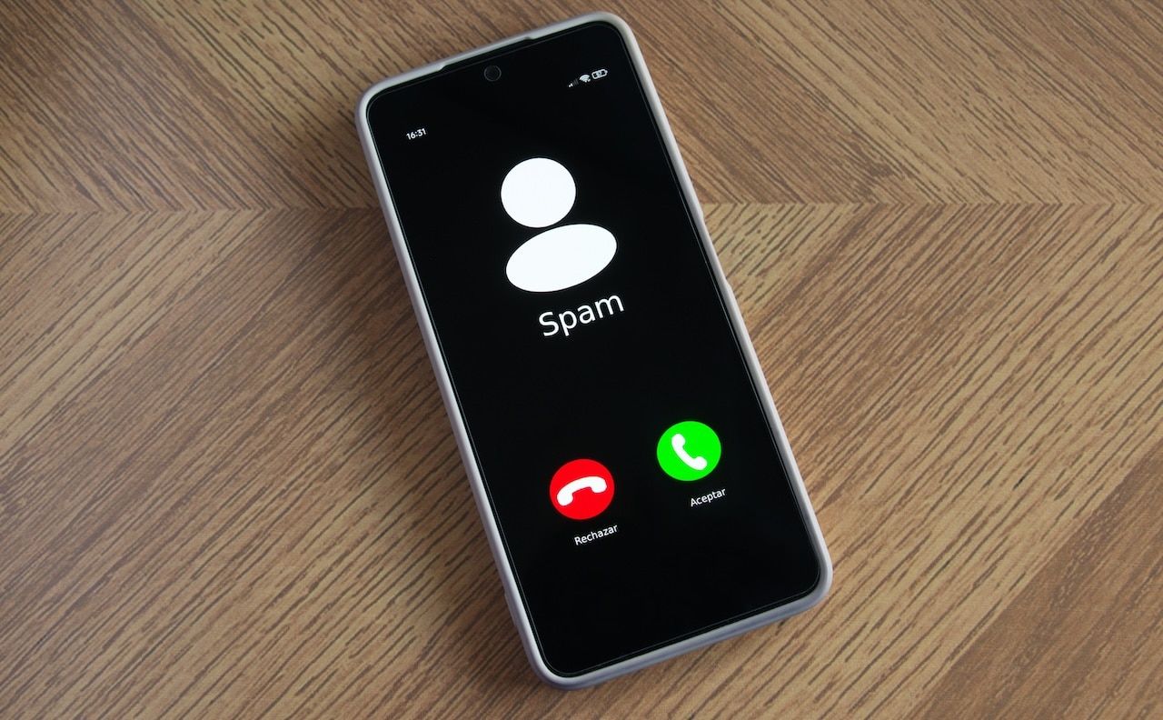 Incoming spam call on mobile phone on table