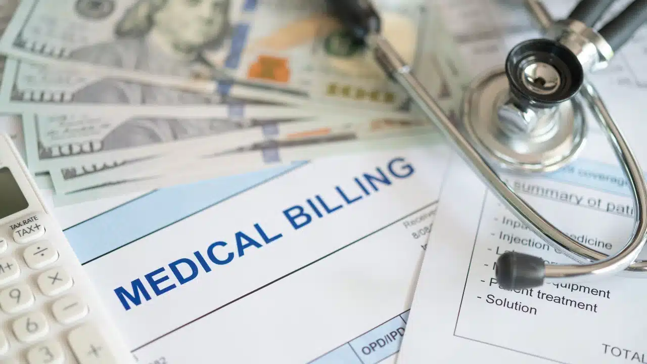medical billing document and dollar banknote, calculator, stathoscope. medical treatment expense concept.