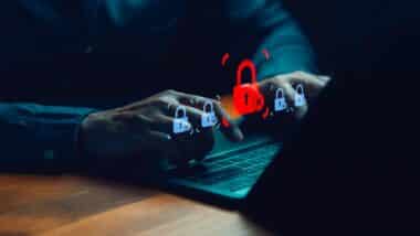 Cybersecurity concept showing person using laptop computer with digital padlock icons