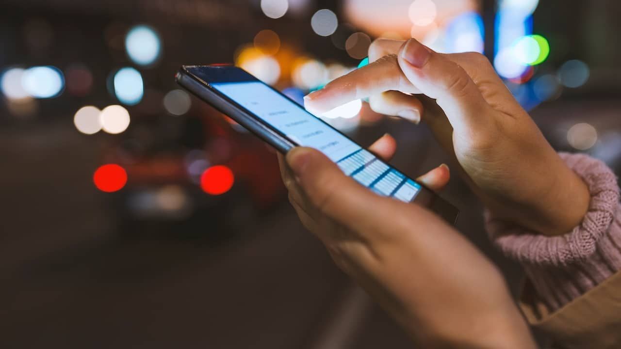 Girl pointing finger on screen smartphone on background illumination
