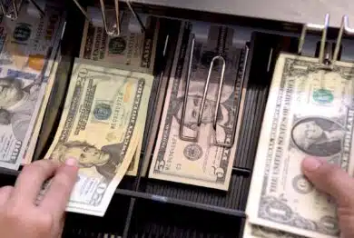 High angle view of cashier searching for change in cash