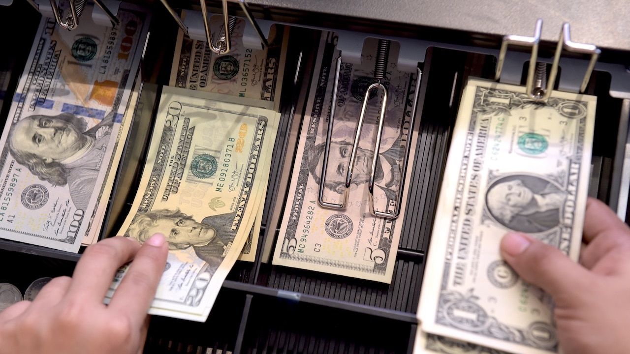 High angle view of cashier searching for change in cash