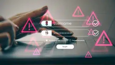 Hands typing on laptop with glowing warning icons in soft light background showing concept of online security threat and safety