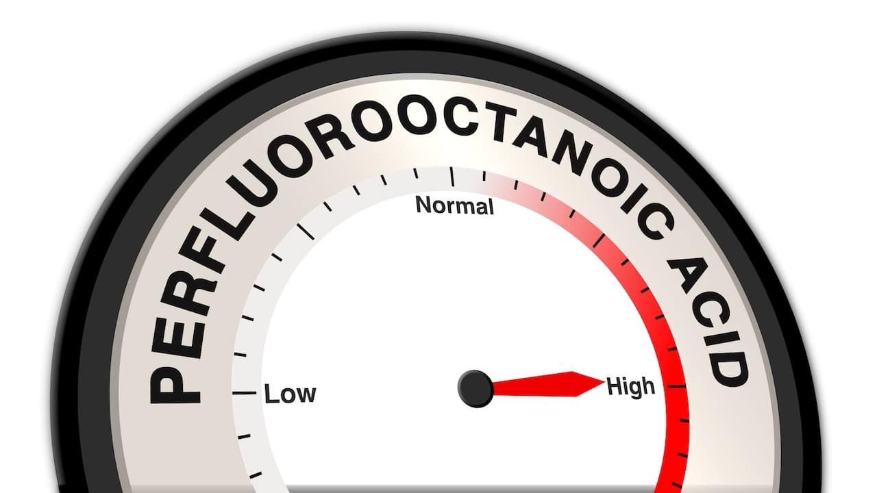 words Perfluorooctanoic Acid with a barometer or tachometer showing a high level, representing strong chemical hazard, high exposure risk, and critical environmental or health concern concept
