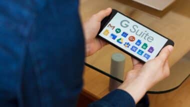 Close up to female hands holding smartphone using G Suite application