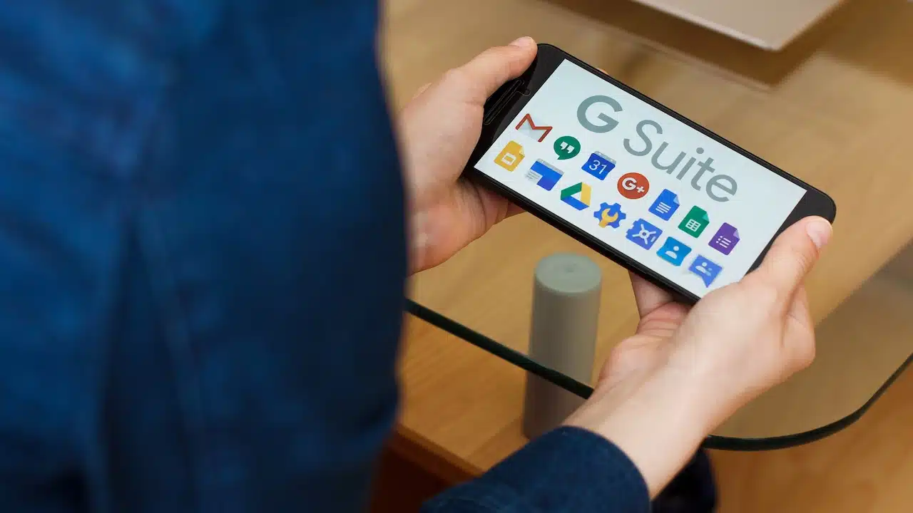Close up to female hands holding smartphone using G Suite application