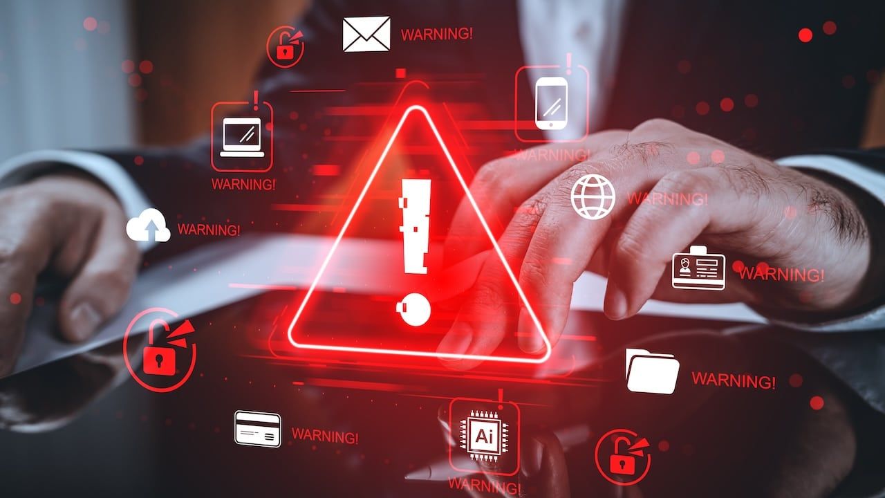 Hands using tablet with red alert icons, glowing modern graphic style on blurred background.