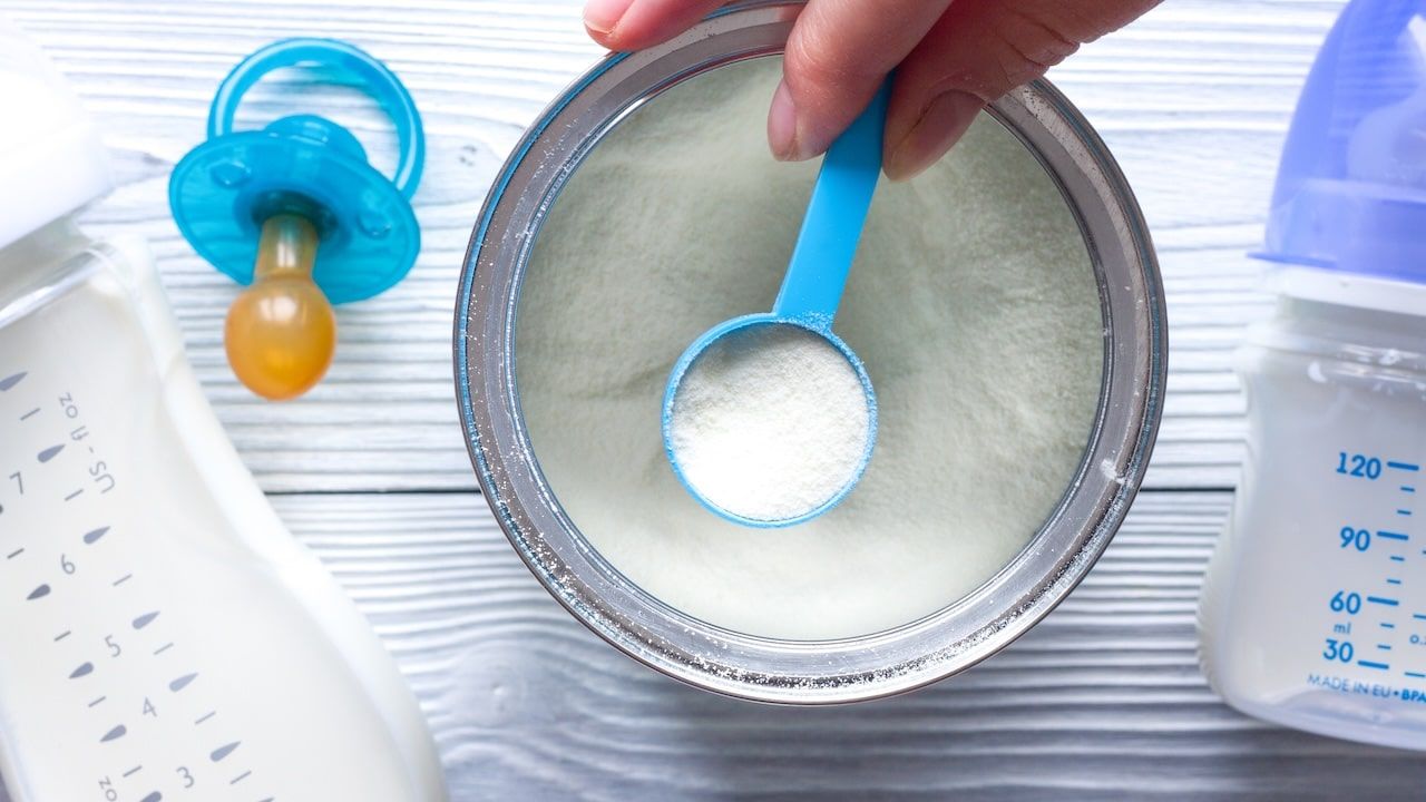 preparation of mixture baby feeding on wooden background.