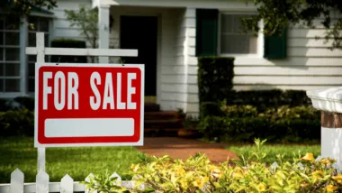 House with a generic for sale sign in front yard.