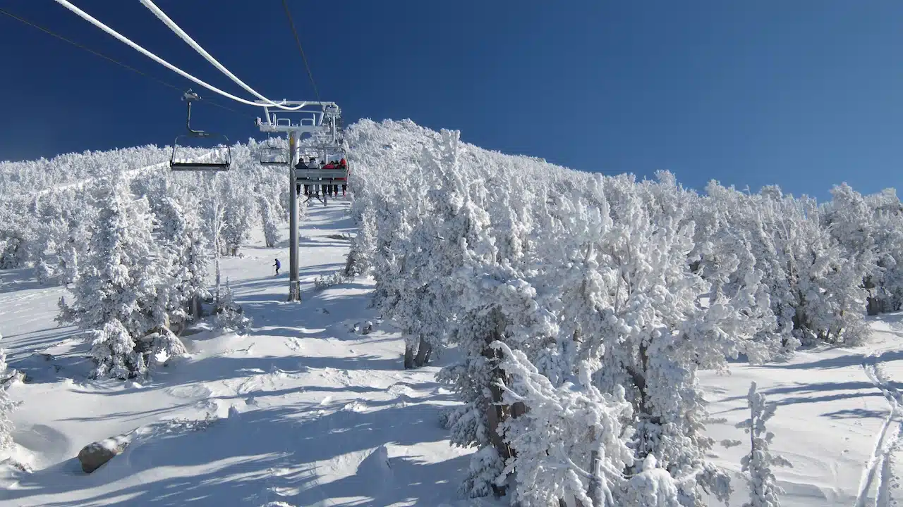 Skiers are riding a ski lift on a skiing resort at Lake Tahoe.
