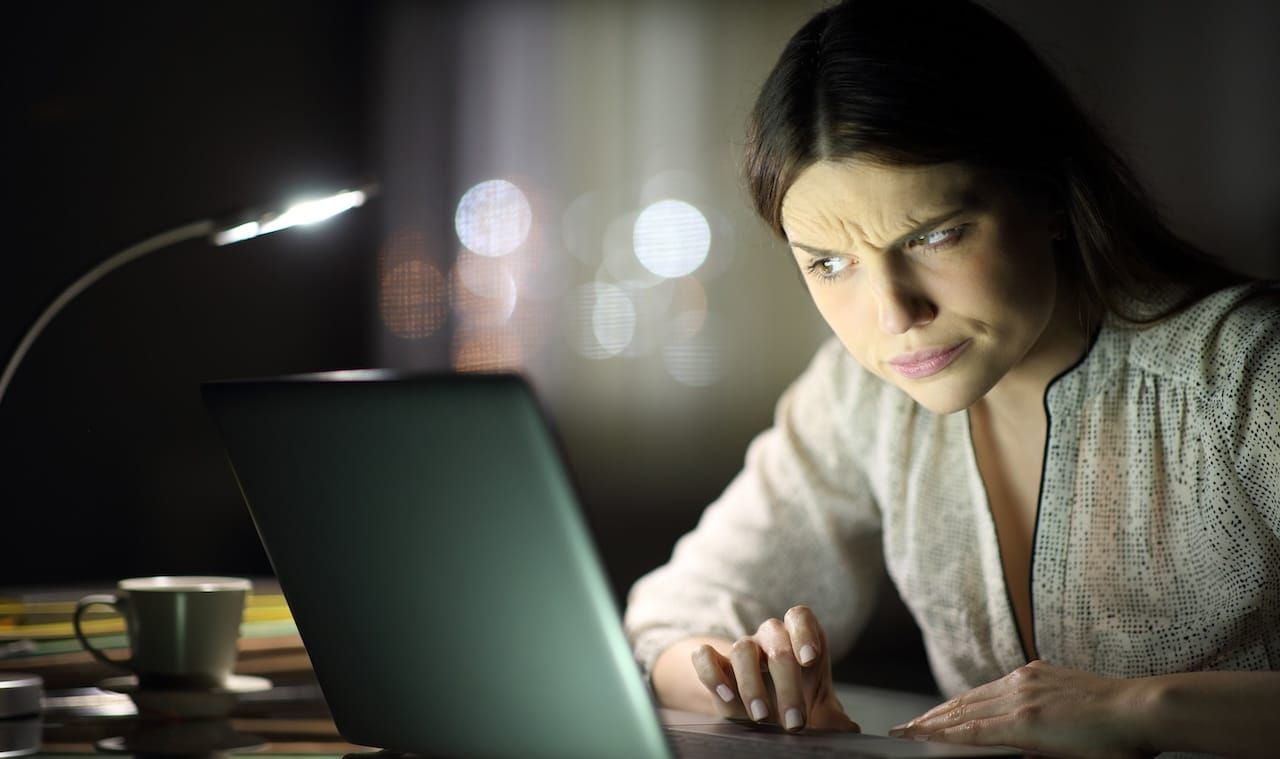 woman checking laptop content late hours