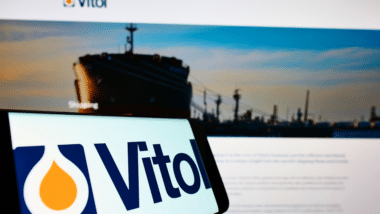 Mobile phone with logo of Dutch trading company Vitol Holding B.V. on screen in front of business website.