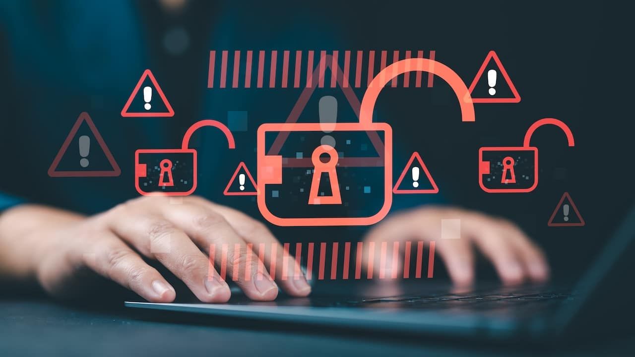 Hacking and system intrusion concept with a hacker using a laptop to steal data