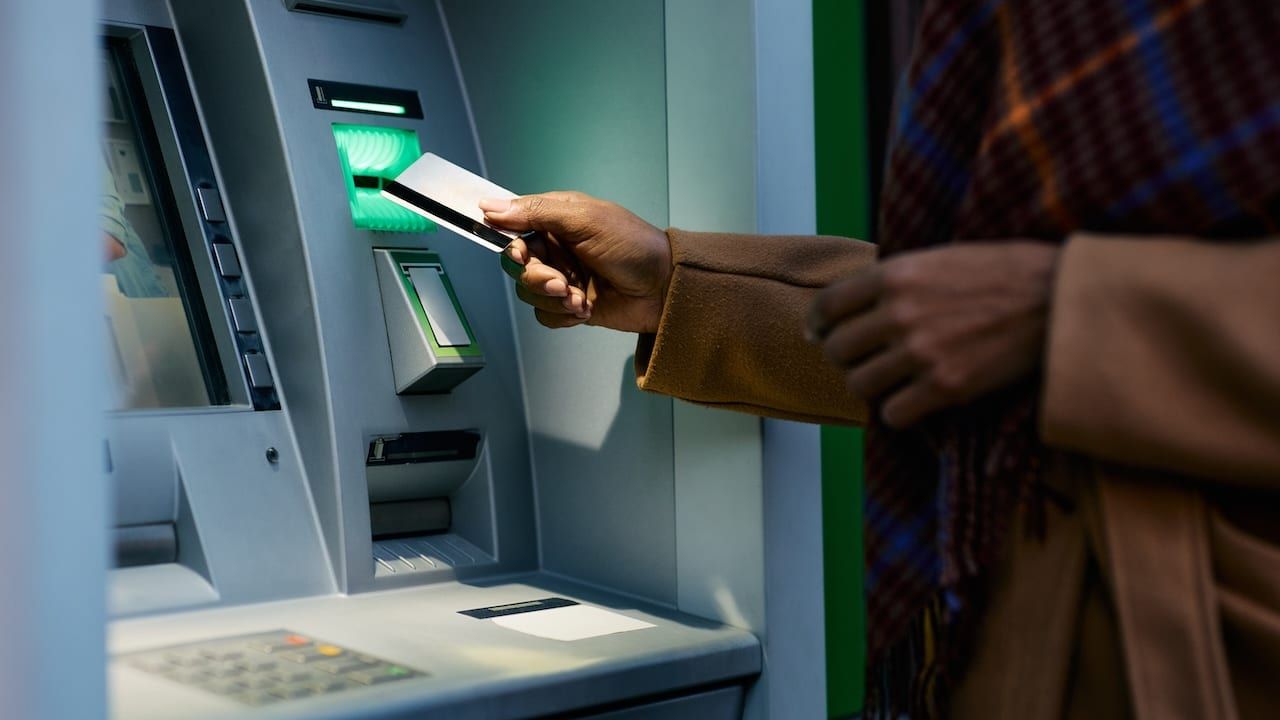 woman withdrawing money from ATM machine