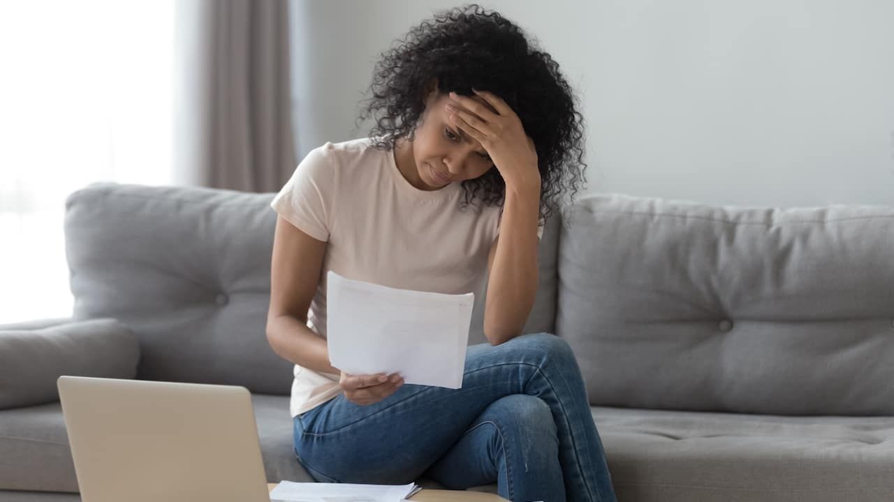 Stressed african woman holding papers calculate insurance bills