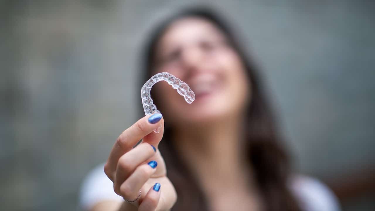 Woman with invisible teeth bracket aligner