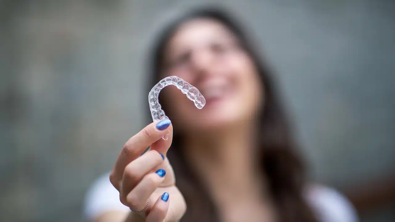 Woman with invisible teeth bracket aligner