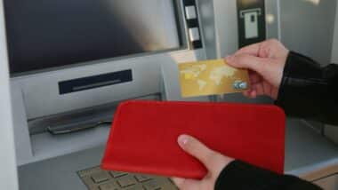 Woman using cash machine for money withdrawal outdoors