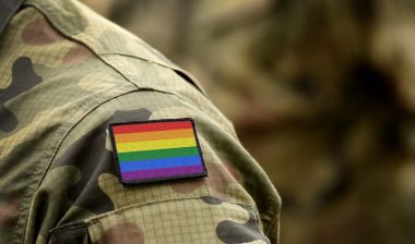 Close up of a rainbow flag patch on a military uniform, representing the LGBTQ vets class action.