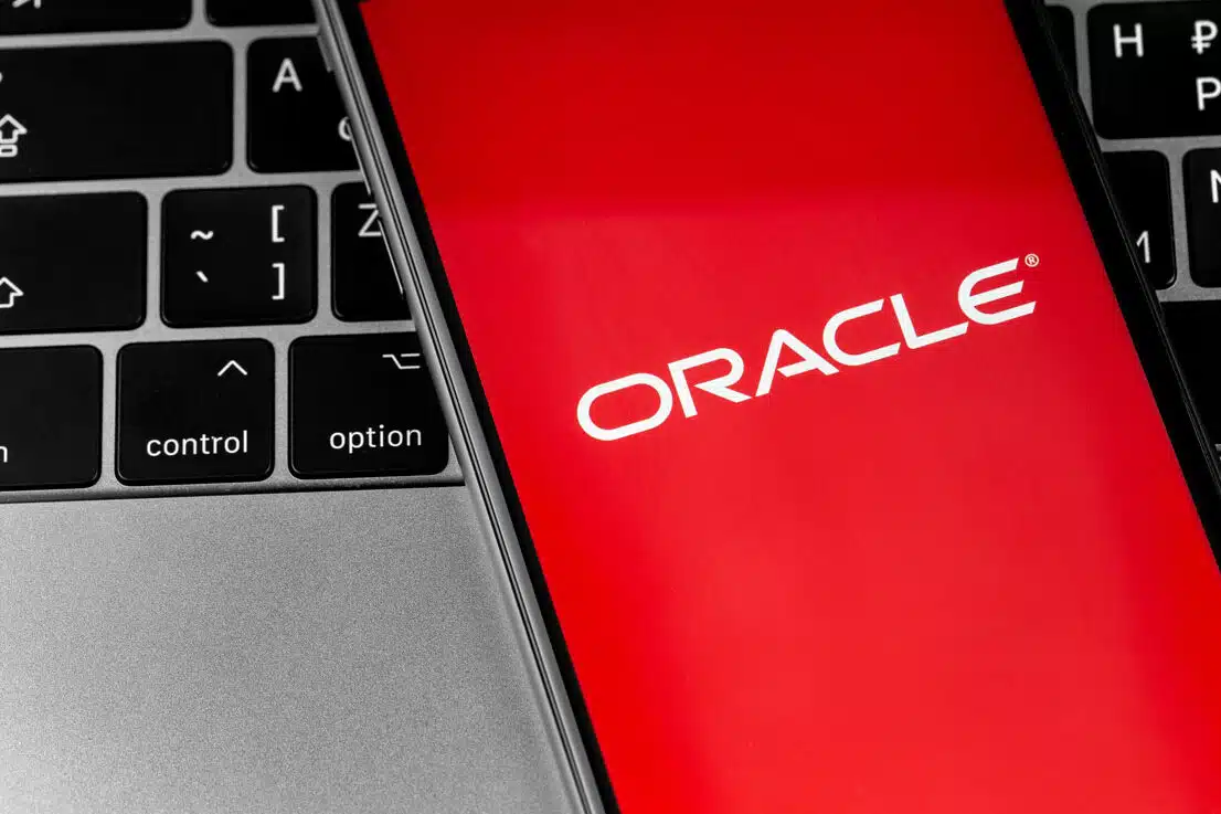 Oracle logo app on the red screen smartphone with keyboard closeup, representing the Oracle America Inc. class action alleging the company sells personal information to third parties.