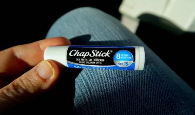 Close up of a hand holding a. Chap Stick brand product, representing the ChapStick settlement.