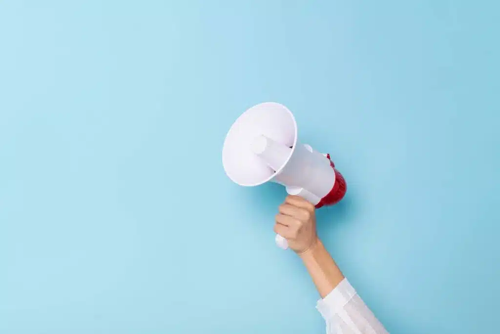 A hand holding a megaphone against an isolated background, representing top recalls for the week of July 8.