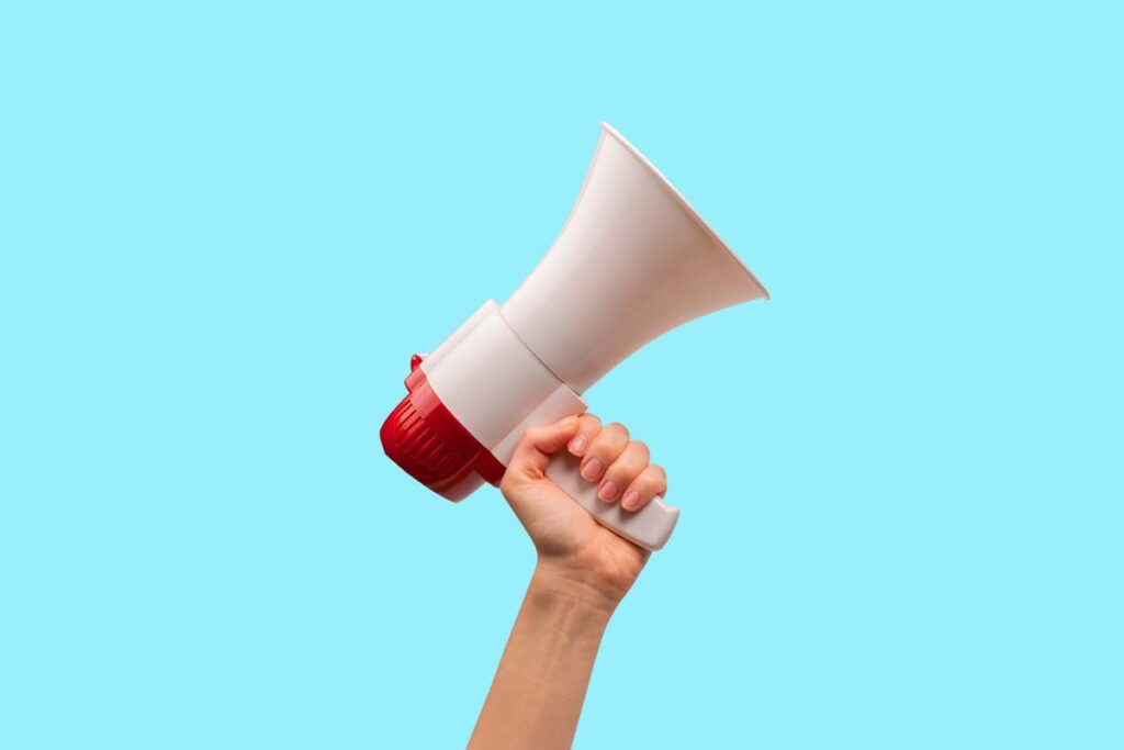 A hand holding a megaphone against a blue backdrop, representing top recalls for the week of July 15.